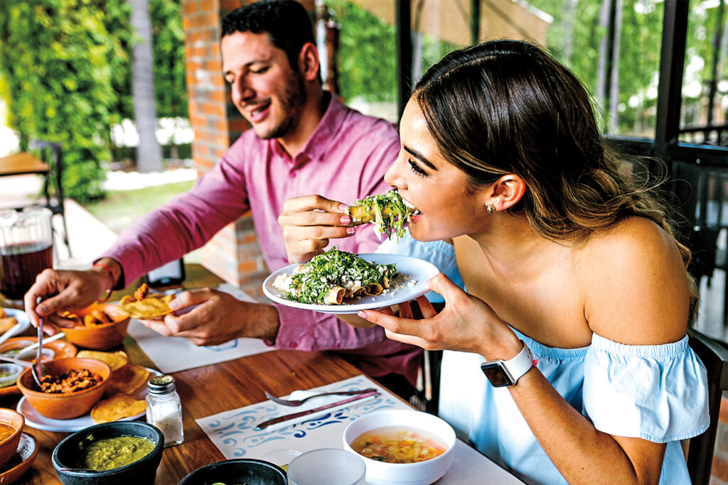 woman and man eating Mexican food at restaurant