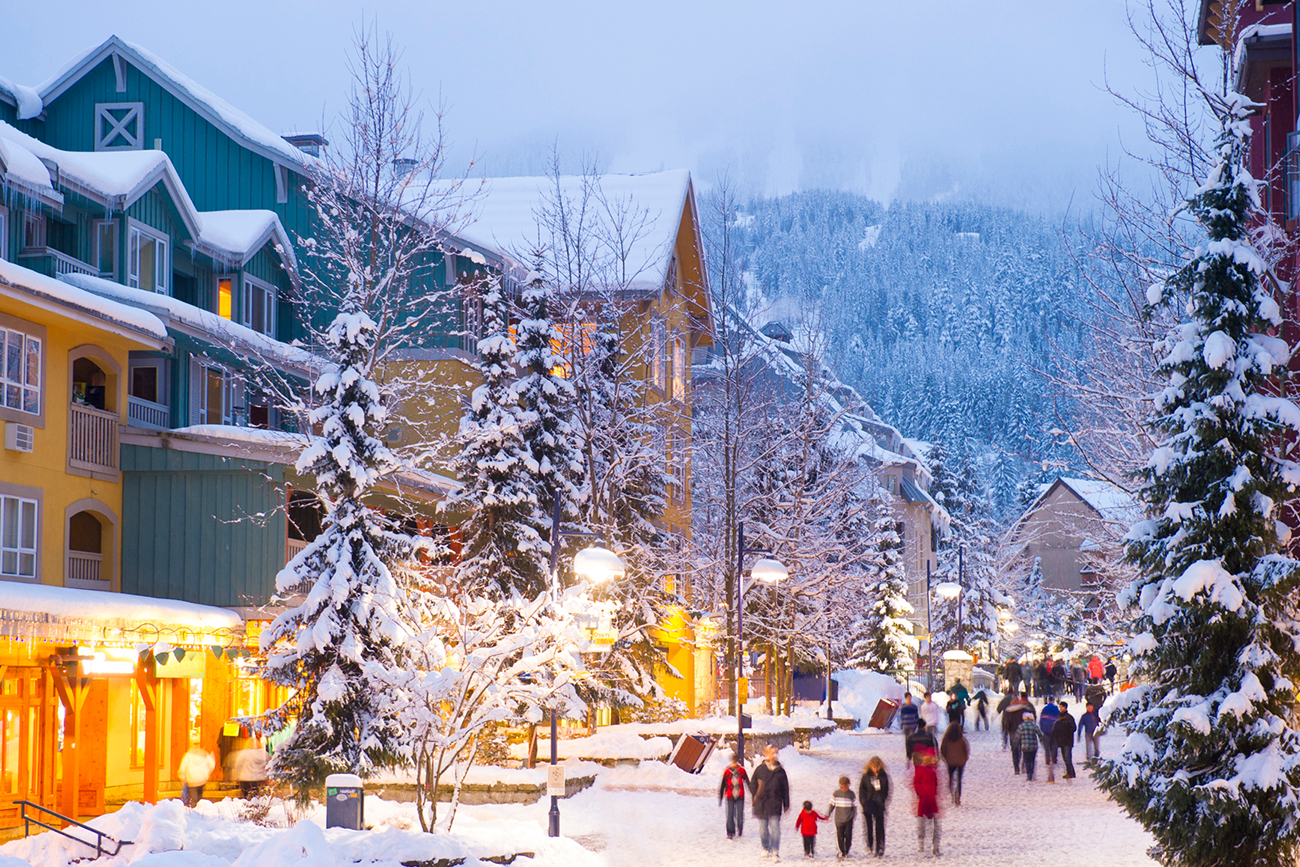 village covered with snow at winter with crowds of people walking around
